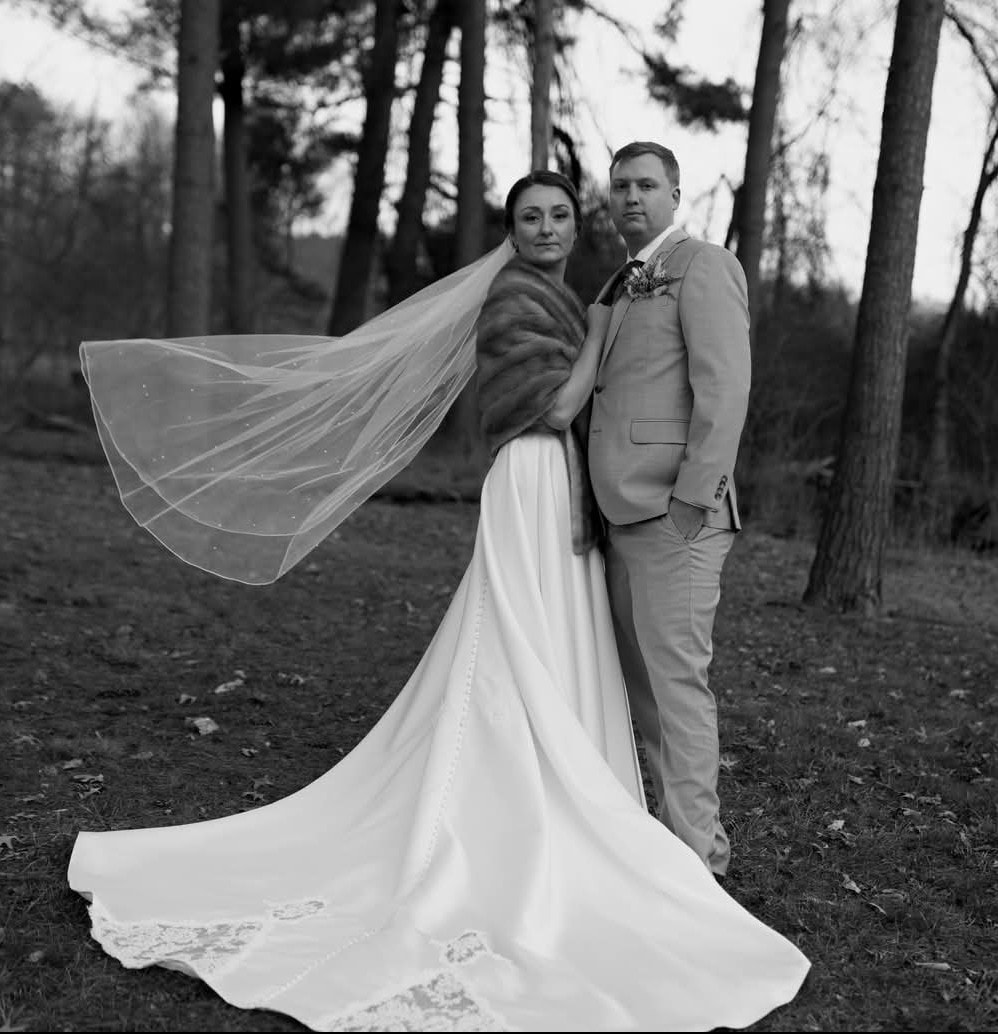 Bride and groom black and white forest portrait with flowing veil